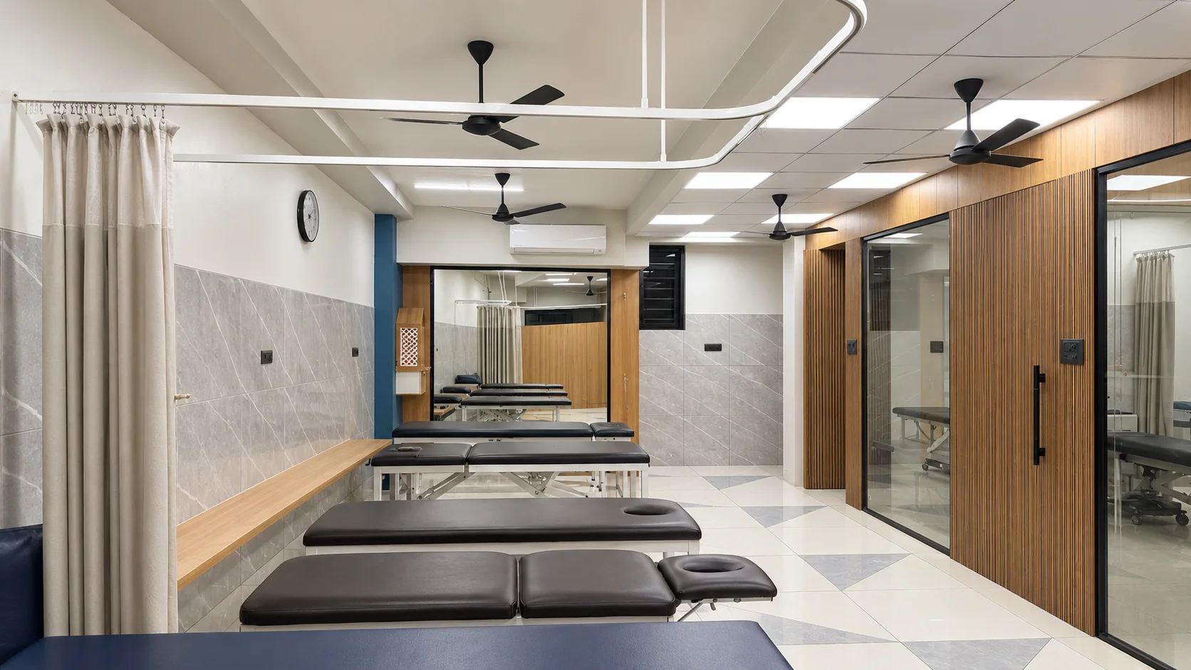 Spacious rehabilitation room with private curtains and treatment tables